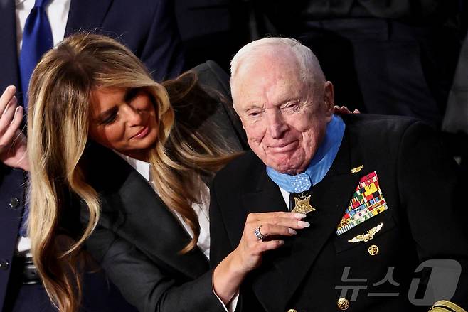 24일(현지시간) 워싱턴 DC 미국 국회의사당 하원 회의장에서 열린 도널드 트럼프 미국 대통령의 2기 첫 국정연설 중 영부인 멜라니아 여사가 한국전쟁 참전용사 로이스 윌리엄스(100세)에게 명예훈장을 수여하고 있다. 2026.02.24. ⓒ 로이터=뉴스1