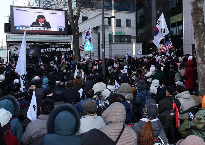 19일 서울 서초구 서울중앙지법 주변에서 윤석열 전 대통령 지지자들이 윤 전 대통령의 ‘내란 우두머리 혐의’ 1심 선고 공판 TV 생중계를 지켜보고 있다. /뉴시스