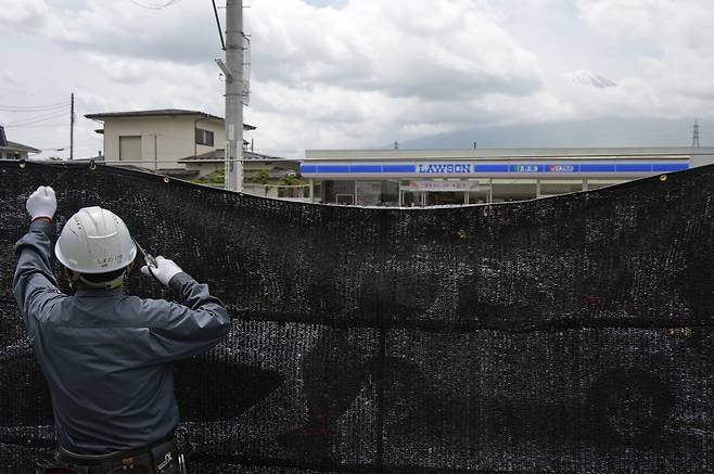 2024년 5월21일 일본 야마나시현 가와구치코의 한 편의점 맞은편에 사진을 찍기 위해 몰려드는 관광객들을 막기 위한 검은색 가림막이 설치되고 있다. EPA연합뉴스