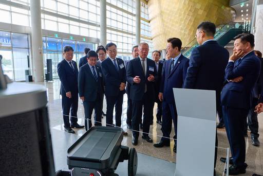 이재명 대통령이 27일 전북 군산새만금컨벤션센터에서 열린 새만금 로봇·수소·AI 시티 투자협약식에 앞서 정의선 현대차그룹 회장으로부터 자율주행휠로봇(MobED)에 대한 설명을 듣고 있다. /연합뉴스 제공