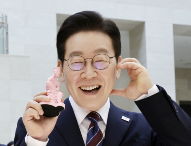 이재명 대통령이 26일 서울 용산구 국립중앙박물관에서 열린 특별전 ‘우리들의 이순신’을 관람한 뒤 상품관에서 기념품을 들고 포즈를 취하고 있다. 연합뉴스