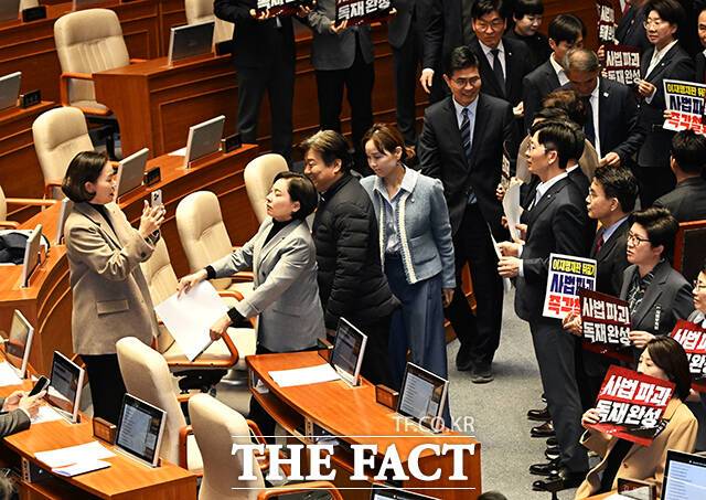 서명옥 국민의힘 의원(왼쪽 두번째)이 27일 서울 여의도 국회에서 열린 제432회 국회(임시회) 제8차 본회의에 참석해 사진을 촬영하던 이해민 조국혁신당 의원(왼쪽)을 향해 피켓을 휘두르고 있다. /국회=배정한 기자