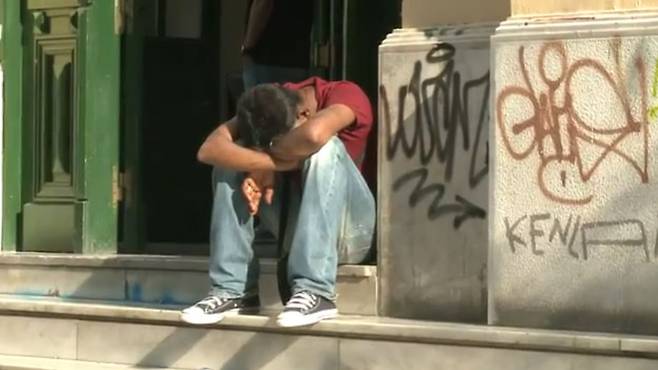 이탈리아 한 도시애서 젊은이가 고개를 숙이고 햇볕을 쬐고 있다./ ILO