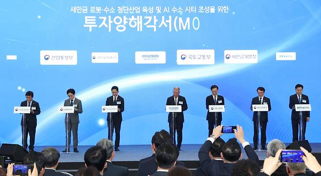 이재명 대통령이 27일 전북특별자치도 군산 새만금 컨벤션센터에서 열린 새만금 로봇·수소·AI 시티 투자협약식에서 투자협약을 체결한 뒤 기념촬영을 하고 있다. 왼쪽부터 김용범 정책실장, 김성환 기후에너지환경부 장관, 김정관 산업통상부 장관, 배경훈 부총리 겸 과학기술정보통신부 장관, 이재명 대통령, 정의선 현대자동차 회장, 김윤덕 국토교통부 장관, 김의겸 새만금청장, 김관영 전북특별자치도지사.=사진제공 전북사진기자단