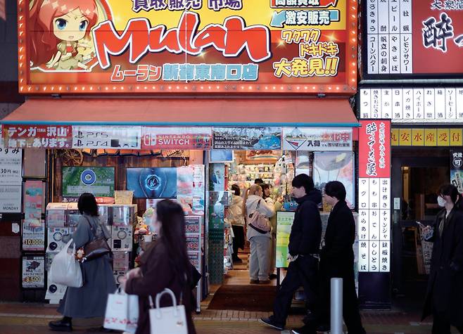 1월9일 일본 도쿄 신주쿠의 쇼핑·유흥가에서 사람들이 한 상점 앞을 지나가고 있다. ⓒEPA 연합