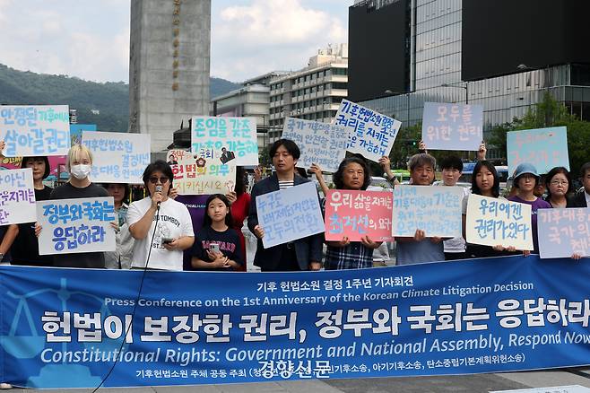 지난해 8월27일, 청소년·시민·아기기후소송과 탄소중립기본계획소송 청구인단 및 변호인단 소속 한 활동가가 27일 서울 광화문 이순신 동상 앞에서 “헌법이 보장한 권리, 정부와 국회는 응답하라”며 기후 헌법소원 결정 1주년 기자회견을 하고 있다. 정지윤 선임기자