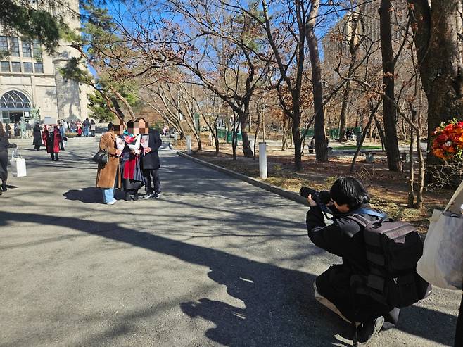 25일 오후 서울 동대문구 경희대학교 중앙도서관에서 사진작가가 졸업생과 가족들의 사진을 찍고 있는 모습./사진=박상혁 기자