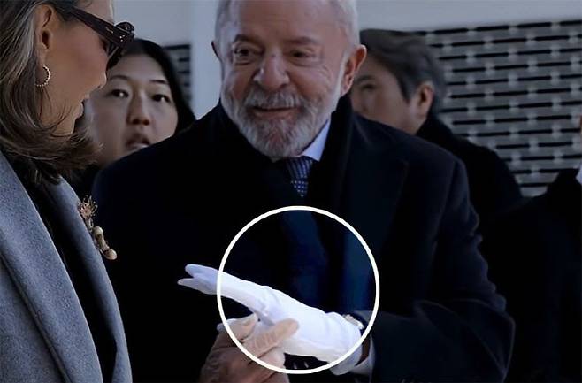 브라질 룰라 대통령이 현충원 참배 당시 장갑을 끼는 과정에서 장갑에 새끼손가락 부분이 없는 것을 보고 깜짝 놀라며 아내에게 전하고 있다. (사진=룰라 대통령 유튜브 캡처)