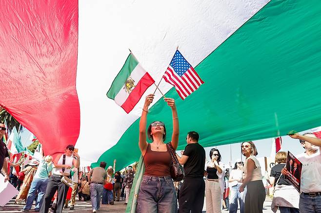 28일(현지시각) 미국 로스앤젤레스에서 시위대가 이란에 대한 미국과 이스라엘의 공습 이후 축하하며 깃발을 흔들고 있다. /EPA연합뉴스.