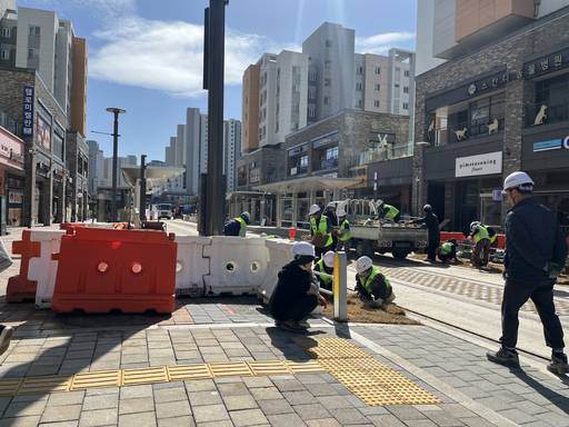 위례신도시 트램 선로 인근에서 작업자들이 보도 경계와 선로 주변 마감 공사를 진행하고 있다. 시운전을 앞두고 시설 정비 작업이 이어지는 모습이다. /성채리 인턴기자