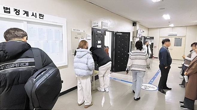 지난달 26일 오전 경매 개시를 앞둔 서울중앙지법 211호 법정 앞에는 입찰 서류를 작성하는 20~30대 젊은 투자자들이 눈에 띄었다. /이지은 땅집고 기자