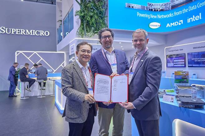 MWC26 슈퍼마이크로 전시관에서 기념 촬영 중인 하민용 SKT AI DC 사업 담당(왼쪽부터), 앤드류 브래드너 슈나이더 일렉트릭 수석 부사장, 클레이 시먼스 슈퍼마이크로 부사장의 모습. /사진=SK텔레콤