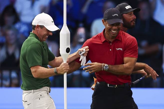 TGL 보스턴 커먼 골프의 로리 매킬로이(왼쪽)가 지난 2일 미국 플로리다주 팜비치 가든스의 소파이 센터에서 열린 주피터 링크스 GC와의 경기 도중 상대팀 타이거 우즈와 함께 웃음을 터뜨리고 있다. TGL 홈페이지 캡처