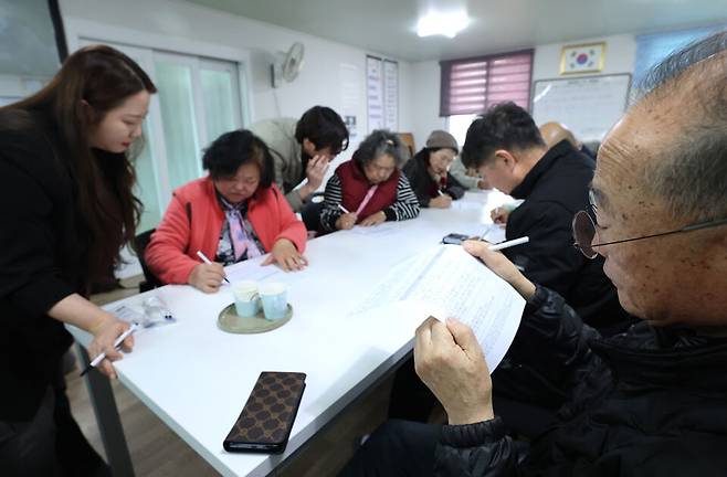 ▲ 포천시 이동면 노곡3리 마을회관에서 오폭 사고 피해 주민들이 PTSD(외상 후 스트레스 장애) 자가진단표를 수기로 작성하고 있다. 사고 지점과 인접한 이 마을 주민들을 위해 마련된 이번 검사는 사고 이후 겪고 있는 심리적 트라우마를 측정하기 위해 실시됐다. /김철빈 기자 narodo@incheonilbo.com