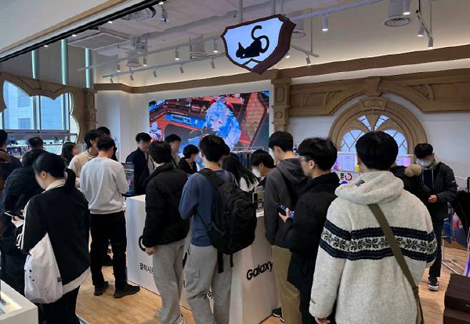 방문객들이 홍대에 위치한 '호요버스 원신 PC 라운지' 내에 마련된 갤럭시 S26 시리즈 체험공간에서 제품을 체험해보고 있다.