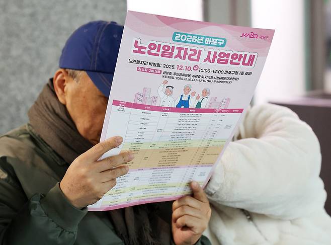 지난해 말 서울 마포구청에서 열린 노인일자리박람회에서 구직자들이 2026년 노인 일자리 사업 안내 팸플릿을 살펴보고 있다. 뉴시스