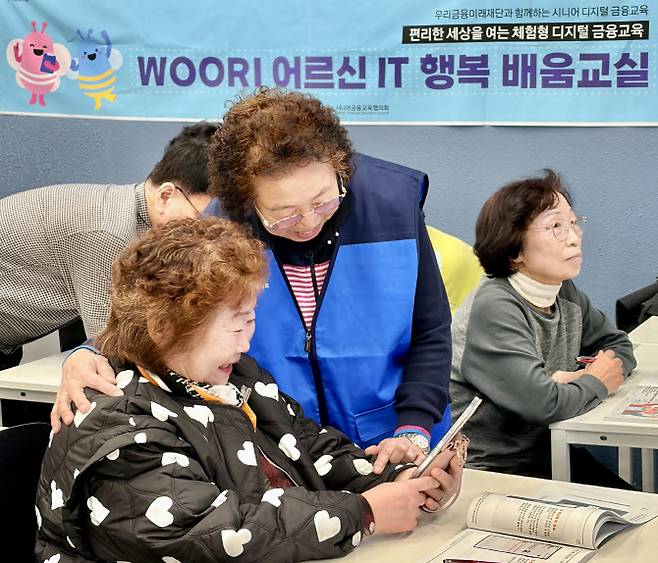 우리 어르신 IT 행복 배움교실에서 전년도 우수 수강생 강옥연씨가 보조강사로 활동하며 다른 수강생들을 돕고 있다. 사진=우리금융 제공