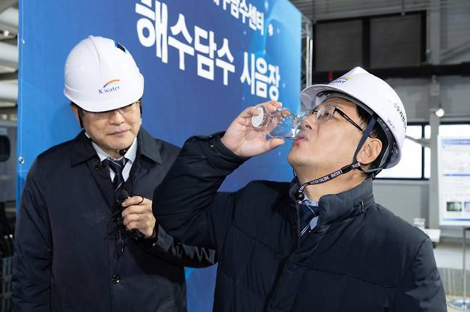 김성환 기후에너지환경부 장관(오른쪽)이 지난해 12월 31일 충남 서산 소재 대산임해 해수담수화 사업 현장에서 운영상황을 점검하고 담수화 처리 후 최종 생산된 물을 시음하고 있다. 뉴시스