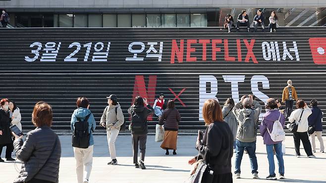 방탄소년단의 컴백 라이브 공연을 일주일여 앞둔 13일 서울 종로구 세종문화회관 계단에 마련된 방탄소년단 공연 홍보물 앞에서 외국인 관광객들이 기념촬영을 하고 있다.허정호 선임기자