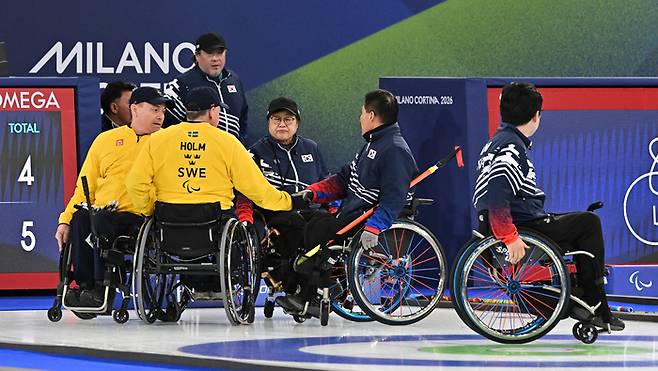 휠체어컬링 한국대표팀 선수들이 13일(현지시간) 이탈리아 코르티나담페초 컬링 올림픽 스타디움에서 열린 2026 밀라노 코르티나 패럴림픽 휠체어컬링 혼성 4인조 스웨덴과의 동메달 결정전에서 패한 뒤 상대와악수를 나누고 있다. 사진 | 코르티나=사진공동취재단