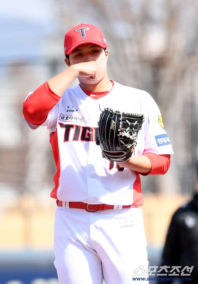 쌀쌀한 날씨 손에 입김을 불어가며 피칭을 시작한 선발 김태형.