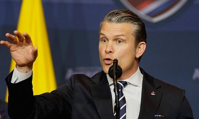 7일 미국 플로리다 도럴에서 열린 ‘실드 오브 아메리카스 서밋’에서 피트 헤그세스 미국 국방부(전쟁부) 장관이 발언하고 있는 가운데, 뒤에서 도널드 트럼프 미국 대통령이 경청하고 있다. AP연합뉴스