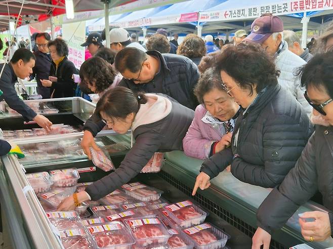 지난 13일 대구 달서구 옛 두류정수장에서 열린 미삼 직거래 장터 삼겹살 판매부스를 찾은 시민들이 삼겹살을 살펴보고 있다. 이승엽기자