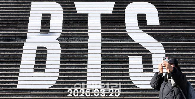 서울 세종문화회관 계단에 설치된 그룹 방탄소년단(BTS) 관련 홍보물 앞에서 한 시민이 인증샷을 찍고 있다.(사진=방인권 기자)