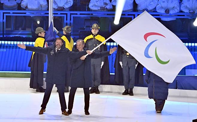 15일(현지시간) 이탈리아 코르티나담페초 컬링 올림픽 스타디움에서 열린 2026 밀라노 코르티나 패럴림픽 폐막식에서 차기 개최지인 프랑스 알프스 관계자들이 패럴림픽기를 흔들어 보이고 있다.2026.3.16 ⓒ 뉴스1 사진공동취재단