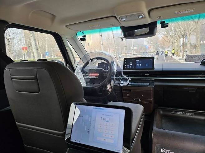 3일 베이징 이좡의 도로를 자율주행 기업 위라이드의 로보택시가 주행하고 있는 모습. 운전석은 승객이 조작하지 못하도록 플라스틱 보호 덮개가 씌워져 있다. 베이징(중국)=이승진 기자