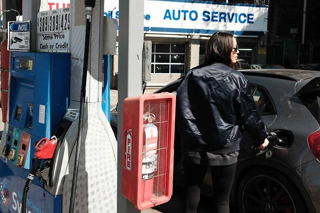 미국 뉴욕 맨해튼의 한 주유소에서 14일(현지시간) 여성 운전자가 기름을 넣고 있다. AFP 연합