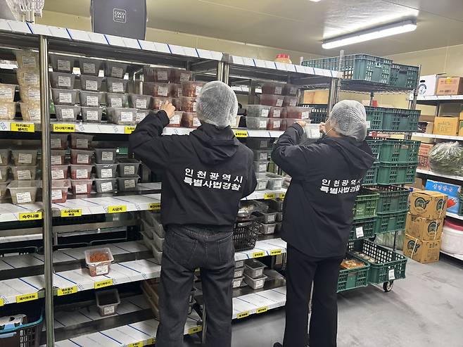 인천시 특별사법경찰이 식품제조업체의 음식을 살펴보고 있다. 인천시 제공