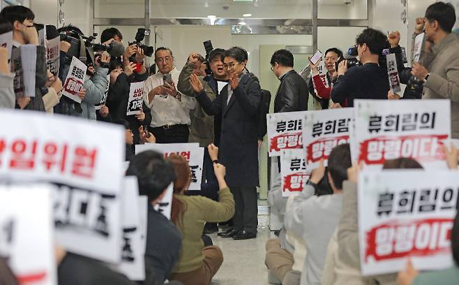 지난 12일 제1차 방송미디어통신심의위원회 정기회의가 열리는 서울 목동 방송회관 회의실 앞에서 김우석 위원이 자신의 임명을 반대하는 언론노조 방미심위지부 조합원들을 향해 인사를 하고 있다. 연합뉴스