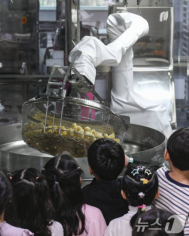 18일 경기 수원시 장안구 대평초등학교 내 위치한 거점형 학교급식 튀김 지원실에서 1학년 학생들이 튀김 조리 로봇이 직접 가동되는 현장을 보고 있다. (공동취재) 2026.3.18 ⓒ 뉴스1 김영운 기자