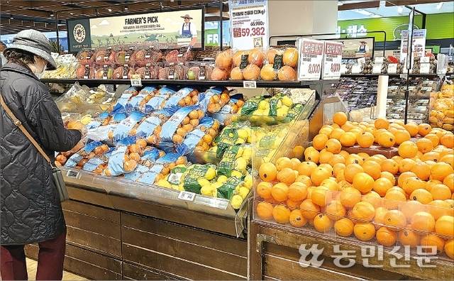 서울시내 한 대형마트에서 소비자가 미국산 만다린 소포장품을 살펴보고 있다. 매대 오른쪽 포장재 없이 낱개로 쌓여 있는 것은 미국산 오렌지다.