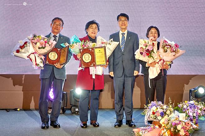 ▲ 김영란(왼쪽 두번째)씨가 대구시(김정기 시장권한대행, 세번째)로부터 '대구자원봉사자 대회'에서 대상을 받고 있다. 대구시