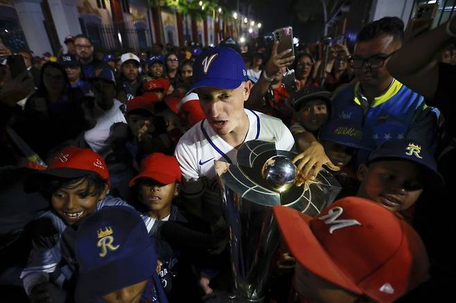 프랑클린 카르디요 로메로 베네수엘라 체육부 장관이 18일(현지 시간) 카라카스 미라플로레스 대통령궁에서 시민들의 환호 속에 2026 월드베이스볼클래식(WBC) 우승컵을 들고 이동하고 있다. 전날 베네수엘라 야구대표팀이 미국을 꺾고 사상 처음으로 우승한 것과 관련해 델시 로드리게스 임시 대통령은 임시 국경일을 선언하고 모든 이가 함께 우승을 축하하자고 말했다.뉴시스