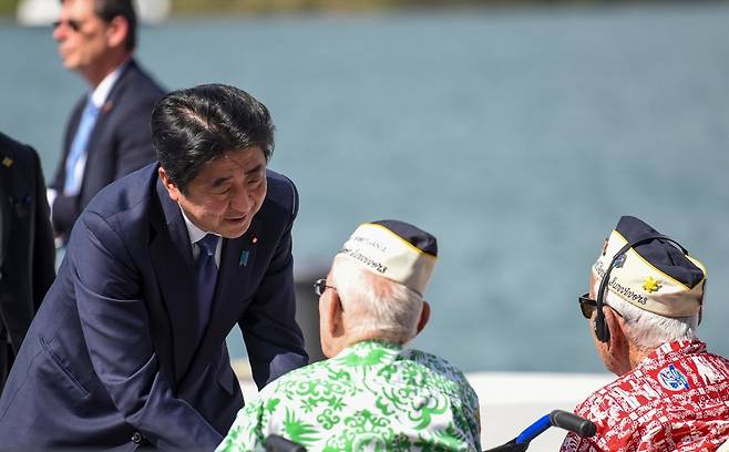 2016년 12월 미국 하와이 진주만 해군 기지를 방문한 아베 신조 당시 일본 총리(왼쪽)가 1941년 일본군의 진주만 공습 당시 생존자들을 위로하고 있다. 미 해군 제공