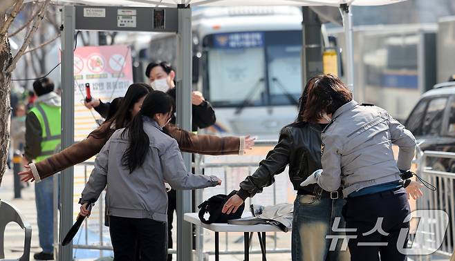 21일 서울 종로구 광화문광장에서 열리는 방탄소년단(BTS) 컴백 공연을 앞두고 경찰이 광장 주변을 오가는 시민과 외국인 관광객을 대상으로 검문검색을 실시하고 있다. 각 게이트에는 문형 금속탐지기가 설치됐으며, 현장에 투입된 경찰관들이 신체와 소지품을 일일이 확인하고 있다. 경찰은 BTS 팬덤 ‘아미(ARMY)’ 대다수가 여성인 점을 고려해 여성 경찰관도 다수 배치했다. 2026.3.21 ⓒ 뉴스1 박지혜 기자