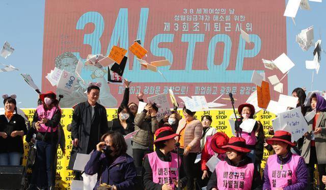 2019년 3월 8일 '세계여성의날'을 맞아 서울 광화문광장에서 열린 '제3회 조기퇴근 시위' 참가자들이 '3시 STOP' 손팻말을 들고 있다. 이들은 한국의 성별 임금 격차를 비판하고 "오후 3시부터의 무급노동을 거부한다"며 시위를 벌였다. 연합뉴스