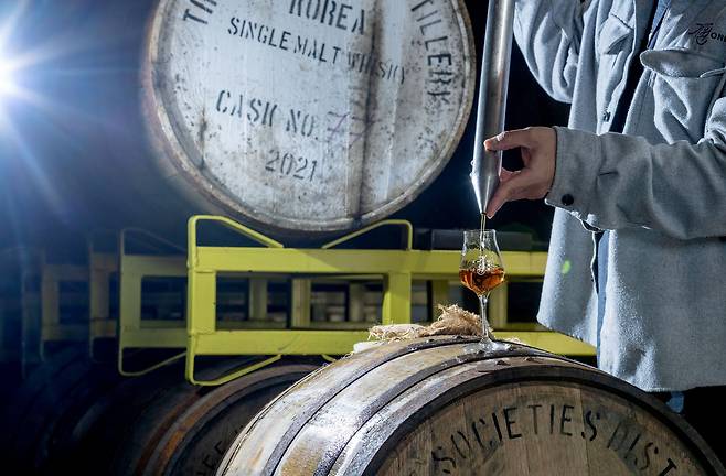 경기도 화도읍에 위치한 기원 위스키 증류소에서 관계자가 시음용 잔을 따르고 있다. 이 오크통은 지난 2020년 7월부터 숙성을 시작한 아메리칸 오크통으로 100번째로 채운 위스키가 담겨있다. 장진영 기자