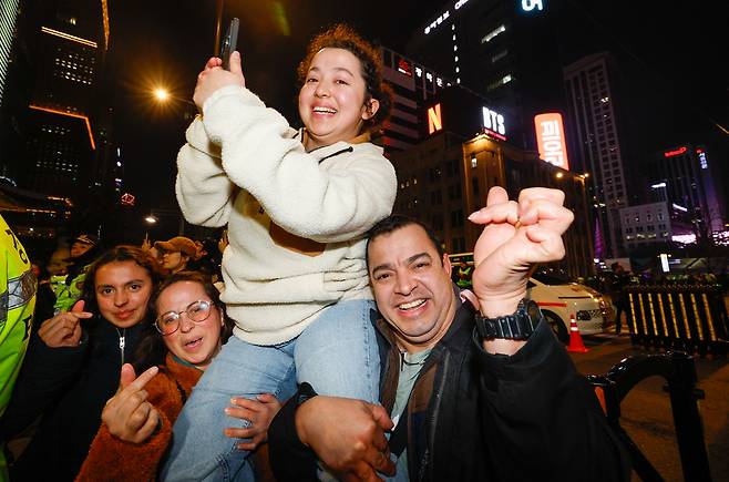 방탄소년단(BTS) 광화문 컴백 공연이 열린 21일 서울 종로구 광화문 광장에서 한 독일 가족이 막내딸을 들어올린 채 공연을 지켜보고 있다.