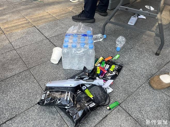 21일 서울 종로구 교보문고 앞에 설치된 금속탐지 출입구(MD) 옆엔 라이터, 커터 칼 등 회수된 금지 물품들이 쌓여있다. 김다인 기자