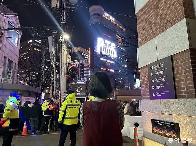 21일 서울 중구 원표공원 뒷골목에서 한 시민이 디지털 사이니지 ‘룩스’로 송출되는 BTS 공연을 관람하고 있다. 김다인 기자