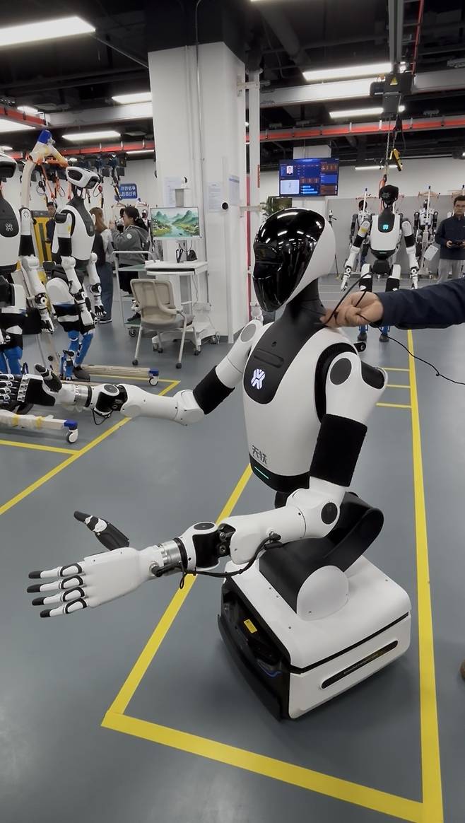 20일 중국 베이징 이좡 경제기술개발구 휴머노이드 로봇 혁신센터 산하 ‘중간시험 검증 플랫폼’에서 휴머노이드 로봇 ‘톈이’가 취재진에게 시설을 설명하고 있다. 베이징=정다은 특파원