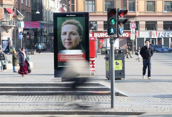 덴마크 총선을 하루 앞둔 23일(현지시간) 코펜하겐 거리에서 시민들이 메테 프레데릭센 총리 겸 사회민주당 대표의 선거 광고판 앞을 지나가고 있다. 코펜하겐(덴마크)=로이터연합뉴스