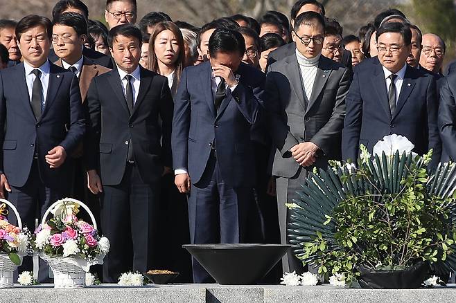 더불어민주당 정청래(가운데) 대표가 23일 경남 김해 봉하마을 노무현 전 대통령 묘역을 참배하며 눈물을 닦고 있다. 정 대표는 이날 “대통령님께 보고드린다. 검찰청은 폐지돼 이제 역사 속으로 사라지게 됐다”고 했다. 앞줄 왼쪽부터 민주당 황명선 최고위원, 한병도 원내대표, 정 대표, 김상욱·허성무 의원./뉴스1