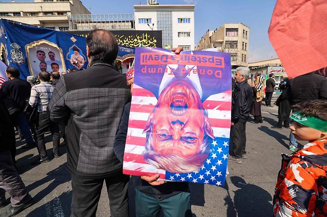 이란 테헤란에서 도널드 트럼프 미국 대통령의 포스터를 들고 있는 사람 ./ AFP 연합뉴스