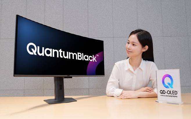 삼성디스플레이의 저반사고강도 필름 '퀀텀 블랙(QuantumBlack)을 적용한 '26년 QD-OLED 모니터 신제품을 모델이 소개하고 있다. (사진=삼성디스플레이)
