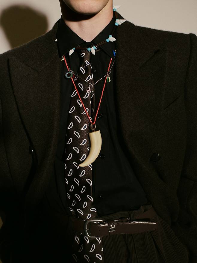 안 어울릴 것 같은, 서로 다른 분위기의 아이템을 조합해 새로움을 만들어 내는 것이 마이클 라이더의 놀라운 능력이다. 그는 정갈한 재킷과 타이 차림 위에 혼 펜던트의 빨간 가죽 줄 목걸이를 착용시켜, 정통성과 여유로움을 동시에 표현했다. 사진 셀린느